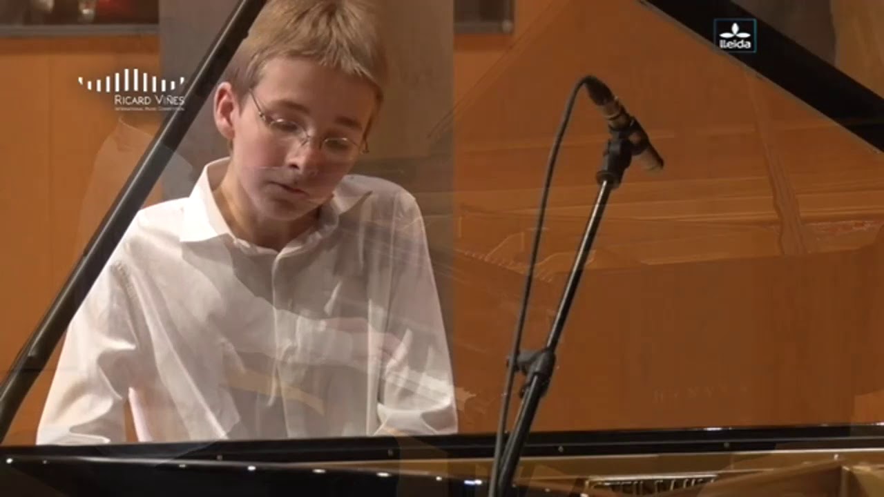 Alexander Denisov performing at a grand piano in his early career